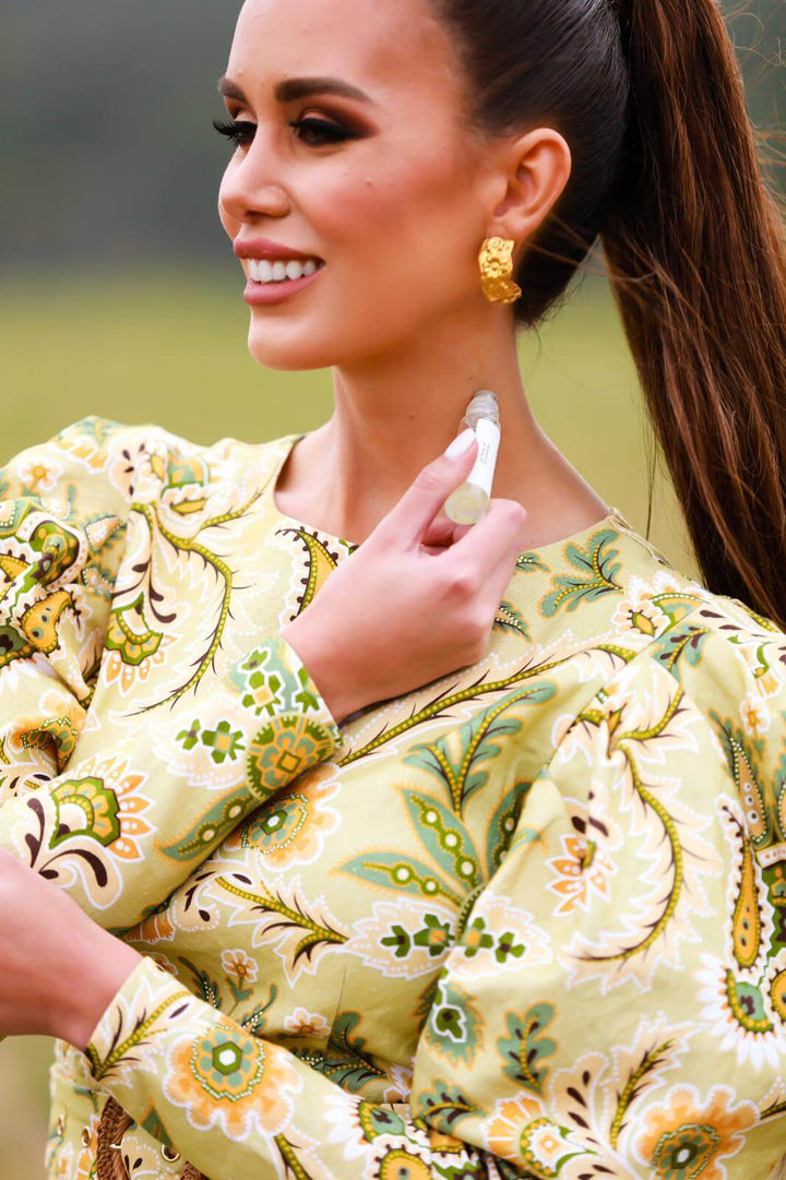 Woman applying Hypnotic Spell Perfume Oil to her  neck, demonstrating the roll-on application method